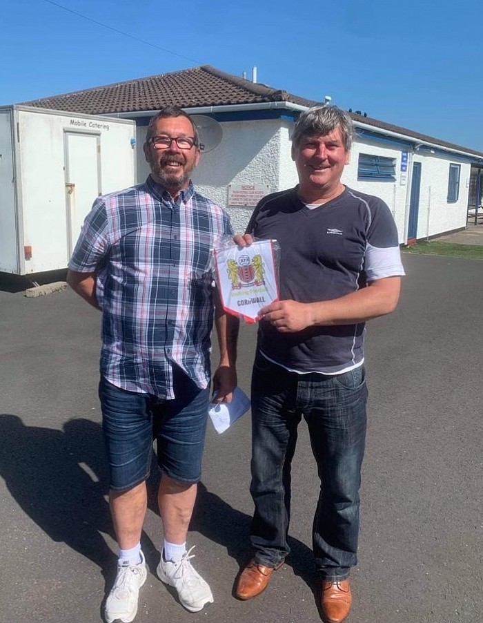 Our pennant is gifted to Troon FC Vice Chair Billy Ingle in a lavish twinning ceremony which involved a break from painting the fence!